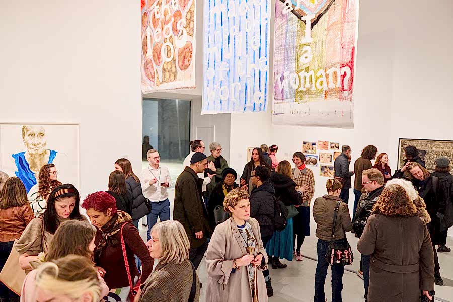 A wide shot of a crowd in a gallery