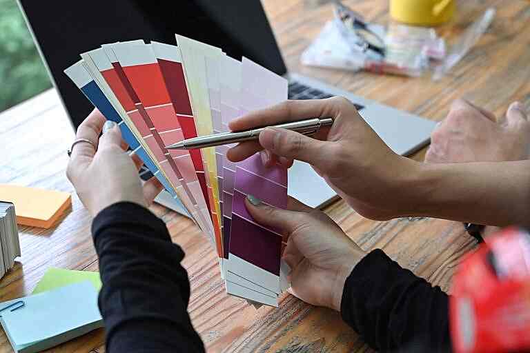 Team of creative designer choosing colors from palette guide for